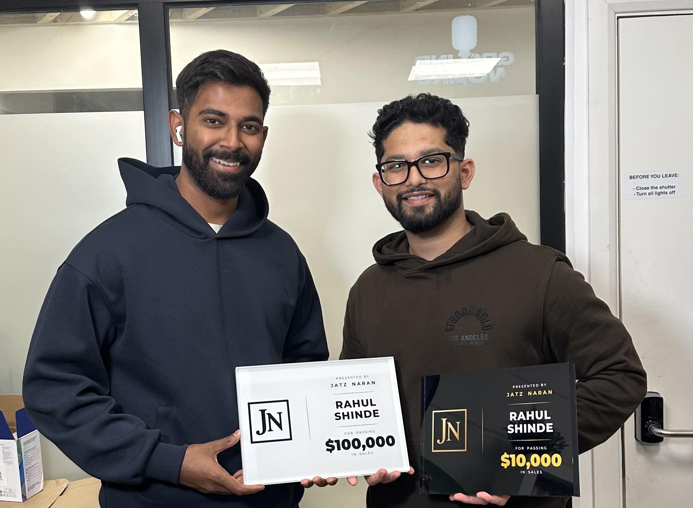 A student collecting his £10K and £100K milestone plaques